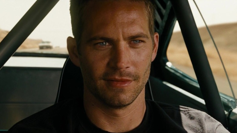 Paul Walker's Brian O'Conner smiling and driving a car in Fast & Furious