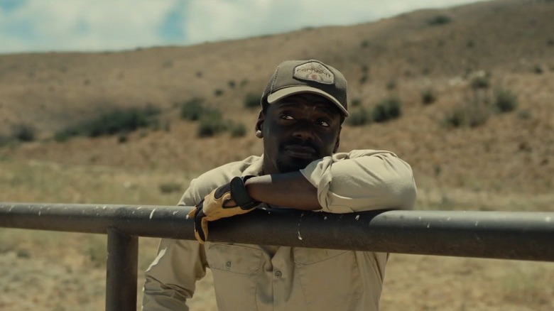 Daniel Kaluuya as OJ leaning on the stable fence in NOPE