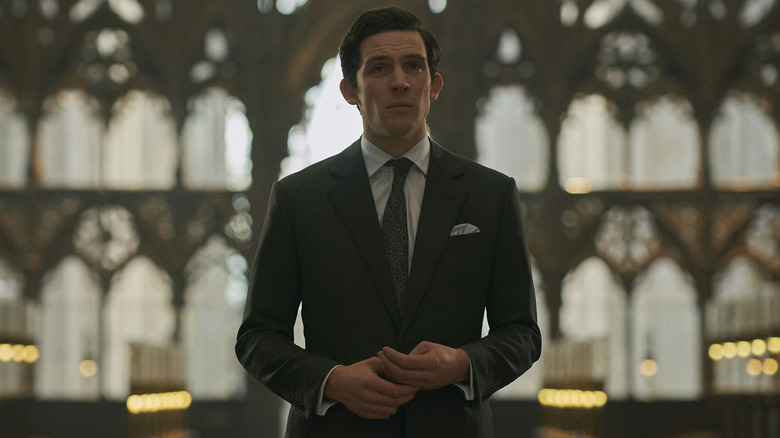 Josh O'Conner as Prince Charles standing in a church in The Crown