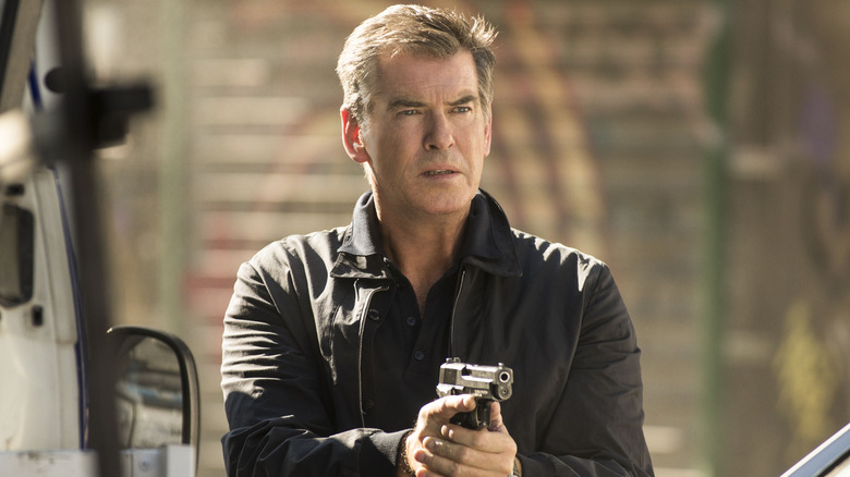 Pierce Brosnan as Peter Devereaux holding his gun in front of him in The November Man