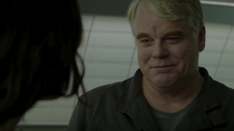 Plutarch Heavensbee smiling at Katniss in Mockingjay Part 2