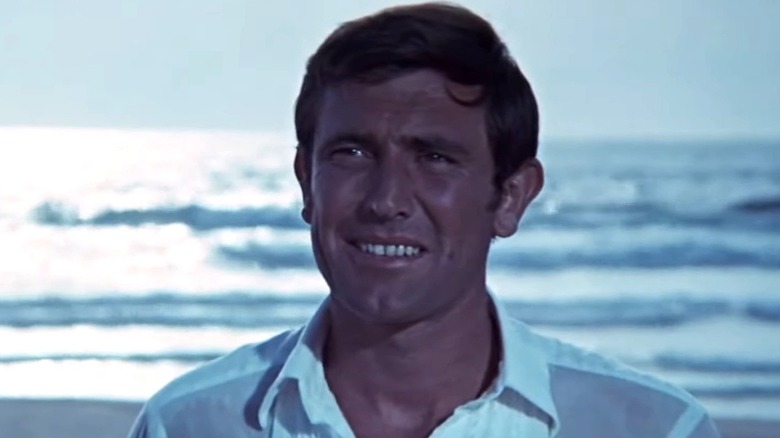 George Lazenby as James Bond smiling in On Her Majesty's Secret Service