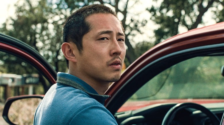 Danny Cho (Steven Yeun) looks over his shoulder as he enters his car in Beef