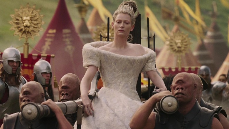 Tilda Swinton as the White Witch, who is being carried on a throne through an army camp in Chronicles of Narnia