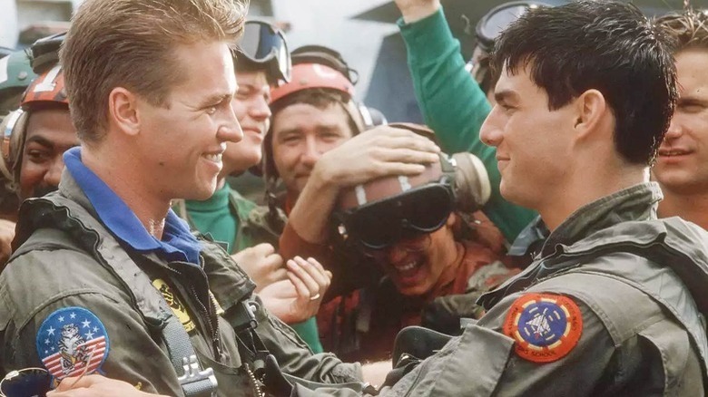 Val Kilmer and Tom Cruise smiling in Top Gun