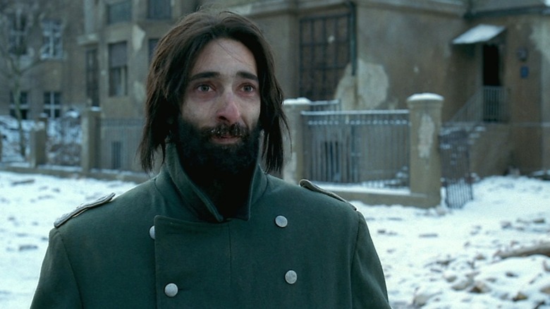 A bearded, thin Adrien Brody outside in the snow as Wladyslaw Szpilman in The Pianist