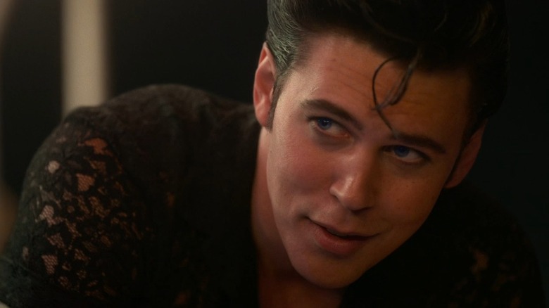 A closeup of Austin Butler as Elvis, smiling with a curl over his forehead