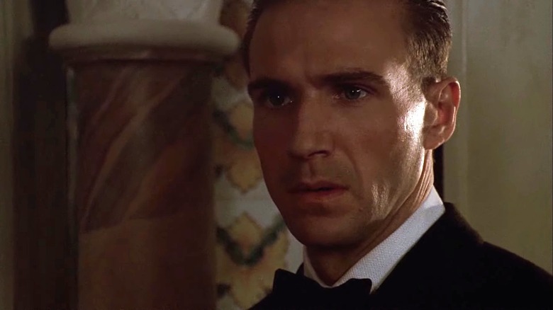 Ralph Fiennes as László Almásy wearing a suit and bow tie in The English Patient