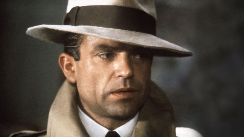 Sam Neill as Sidney Reilly wearing a fedora in Reilly, Ace of Spies