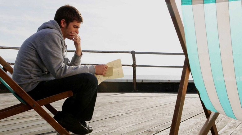 Andrew Garfield as Jack reading letter at pier in Boy A