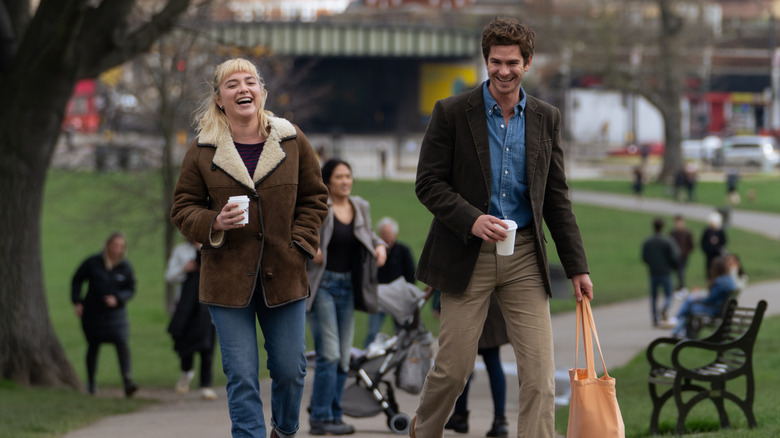 Andrew Garfield and Florence Pugh as Tobias and Almut laughing in park in We Live in Time