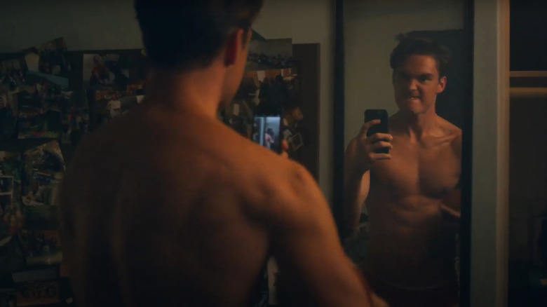 Darren Barnet as Hot Seth, flexing in the mirror with a football on Turnt