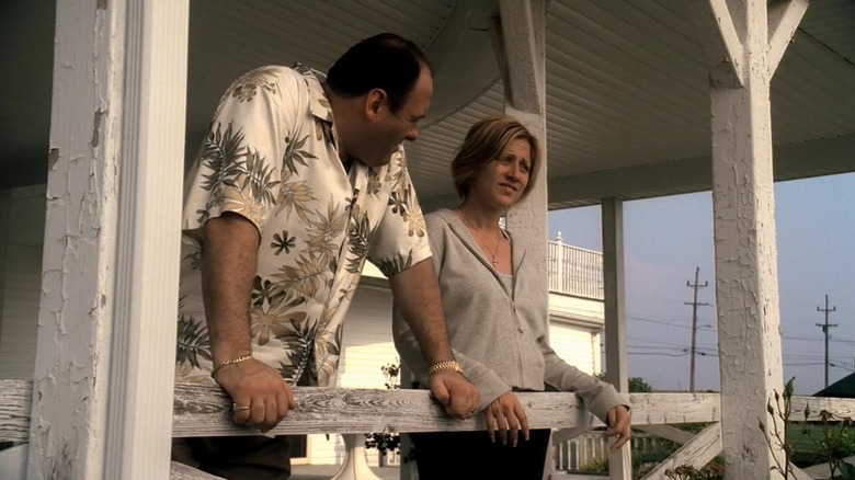 Edie Falco and James Gandolfini as Carmela and Tony on a porch on on the Sopranos