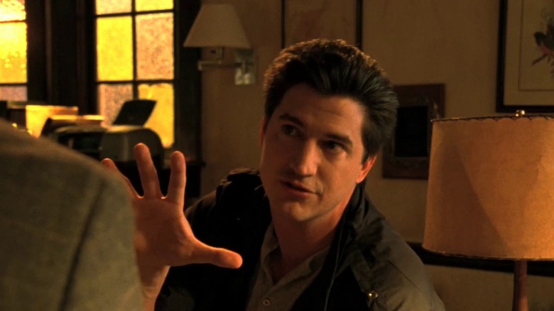 Ken Marino as Vinnie Van Lowe, raising his hand while speaking on the original 2004 Veronica Mars TV series