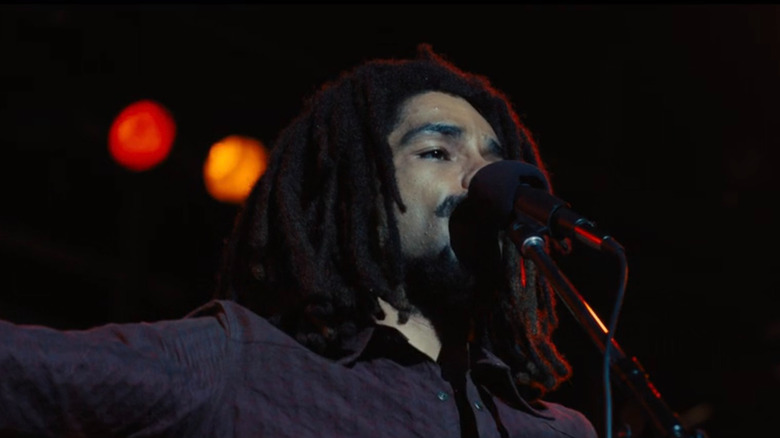 Kingsley Ben-Adir as Bob Marley singing on stage in Bob Marley: One Love