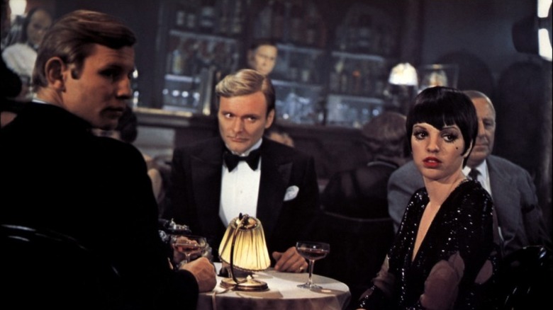 Sally Bowles sits at a table in Cabaret