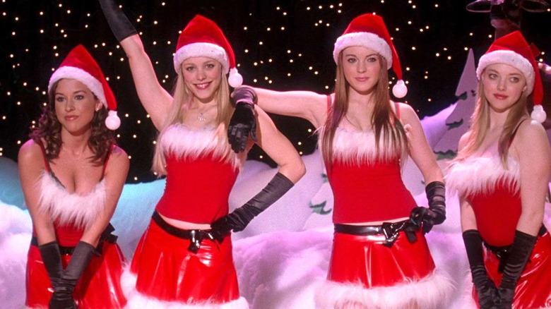 Lacey Chabert as Gretchen Wieners, Rachel McAdams as Regina George, Lindsay Lohan as Cady Heron, and Amanda Seyfried as Karen Smith pose in Santa outfits in Mean Girls