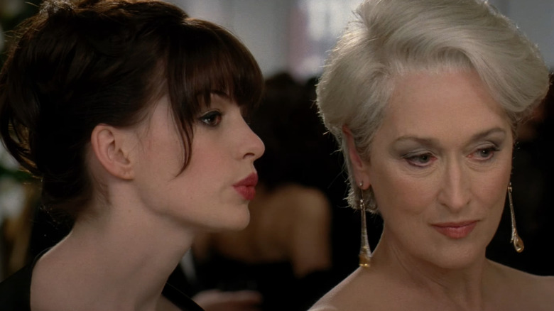 Anne Hathaway as Andy Sachs whispers to Meryl Streep as Miranda Priestly in The Devil Wears Prada