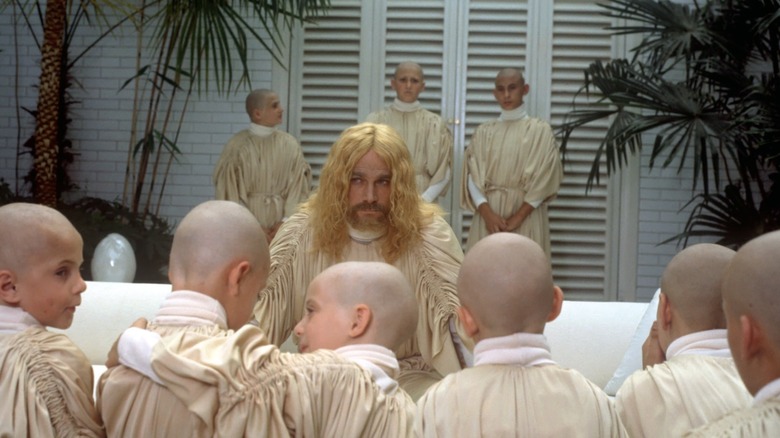 Franco Nero as the prophet surrounded by his bald disciples in The Visitor