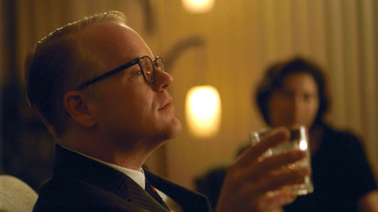 Truman Capote (Phillip Seymour Hoffman) holding a drink in Capote