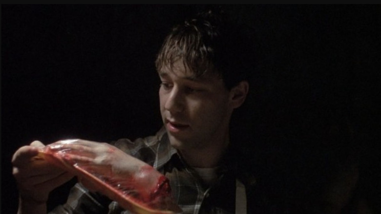 Randy (Sam Raimi) looks at a piece of meat in Intruder