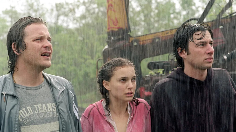 Mark, Sam, and Andrew stand in the pouring rain with their heads angled right, looking quizzically, in Garden State