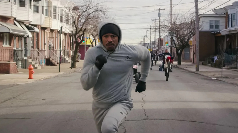 Donnie running down the street in winter gear in Creed