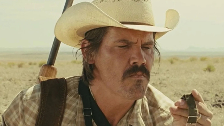 Josh Brolin as Llewelyn Moss in No Country For Old Men looking at a watch