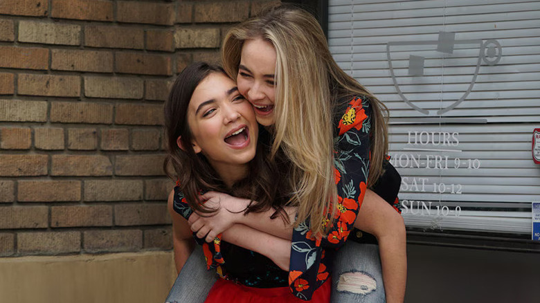 Sabrina Carpenter as Maya piggyback-riding on Rowan Blanchard as Riley in Girl Meets World