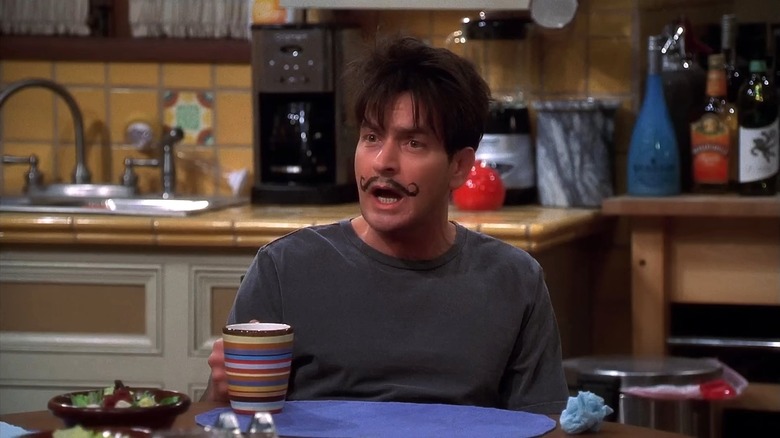 Charlie Sheen as Charlie Harper with a painted-on mustache and speaking in Two and a Half Men