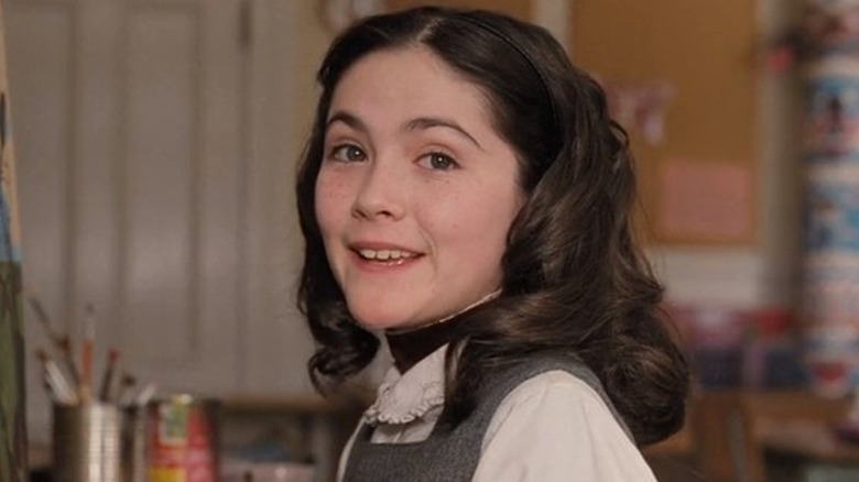 Isabelle Fuhrman as Esther smiles sweetly in front of painting supplies in Orphan