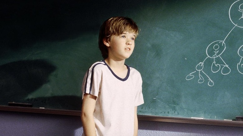 Haley Joel Osment as Trevor demonstrates his pay it forward scheme on a blackboard in Pay It Forward