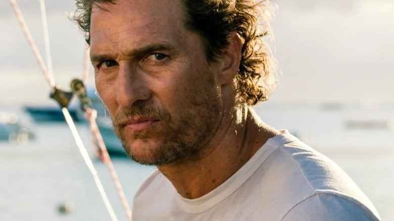 Matthew McConaughey as Dill looks hairy and determined on his white cyberzone boat in Serenity