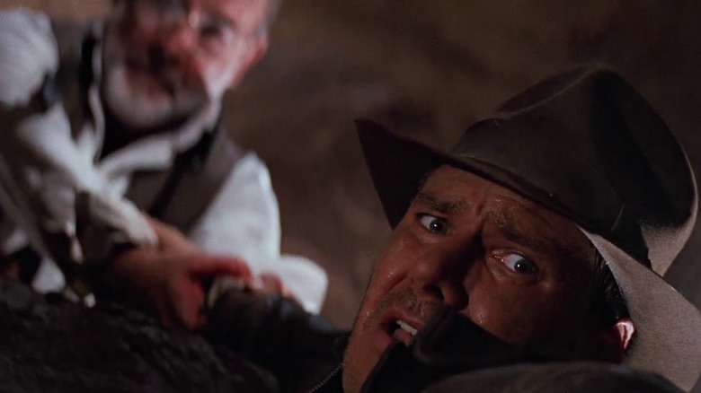 Henry Jones Sr. pulling Indiana Jones up