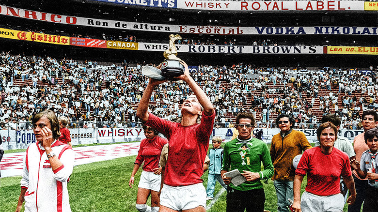 Soccer playing holding up trophy