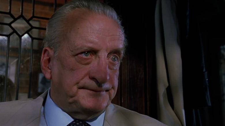 Lieutenant Kinderman (George C. Scott) looking frustrated in front of a glass window, in The Exorcist III