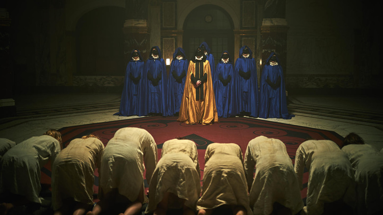 Ares Cultists in robes standing before kneeling people