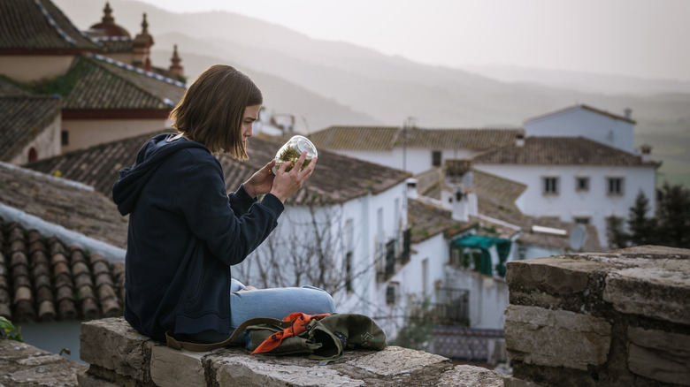 Feria: The Darkest Light Eva sits on wall overlooking village