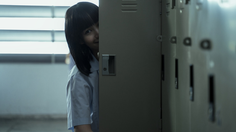 Girl from Nowhere Nanno peeking out from behind school locker