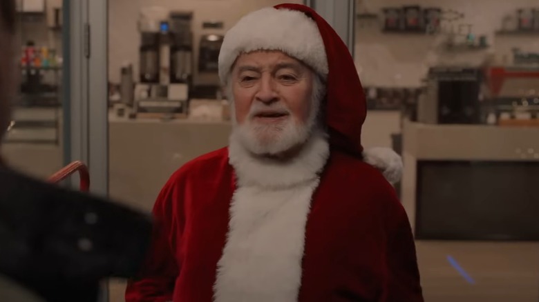 Actual Santa standing in front of a storefront in the movie Santa Tell Me