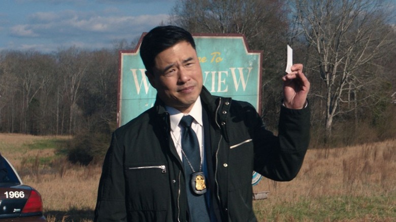 Randall Park holding card outside Westview