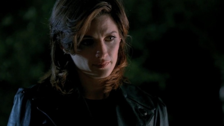 Stana Katic's Kate looking off screen in the dark in Castle