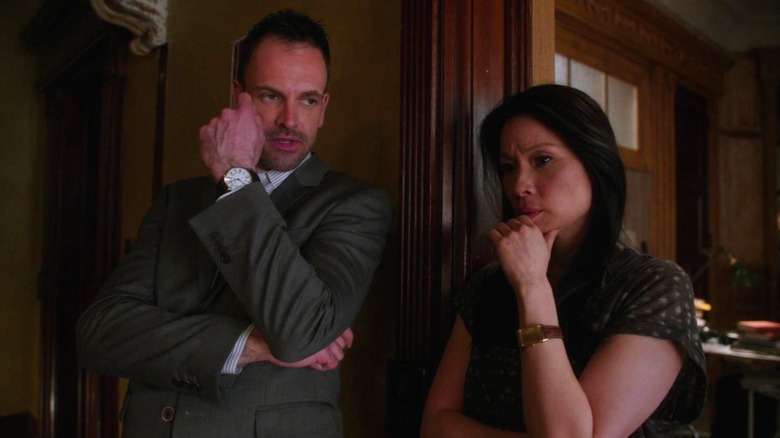 Jonny Lee Miller's Sherlock and Lucy Liu's Jane with their hands on their chins in thought in Elementary