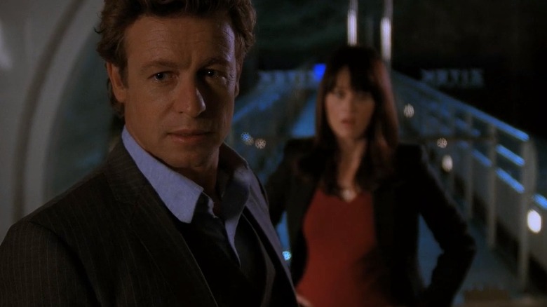 Simon Baker's Jane in the foreground looking offscreen, and Robin Tunney's Teresa in the background looking surprised, in The Mentalist