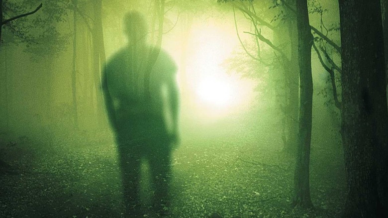 A faded silhouette moves into an unearthly, alien green forest for the cover of The Tommyknockers