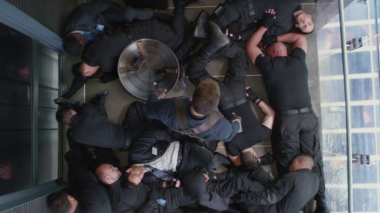 Steve Rogers stands among knocked out SHIELD soldiers in Captain America: The Winter Soldier