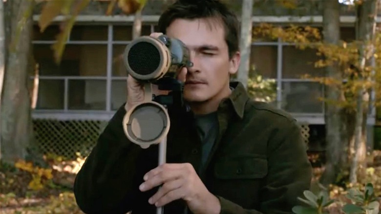 Quinn looks through a scope