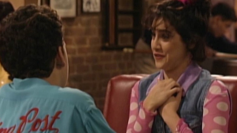 Brittany Murphy's Trini sits across from Ben Savage's Cory in Boy Meets World, with her hands over her heart