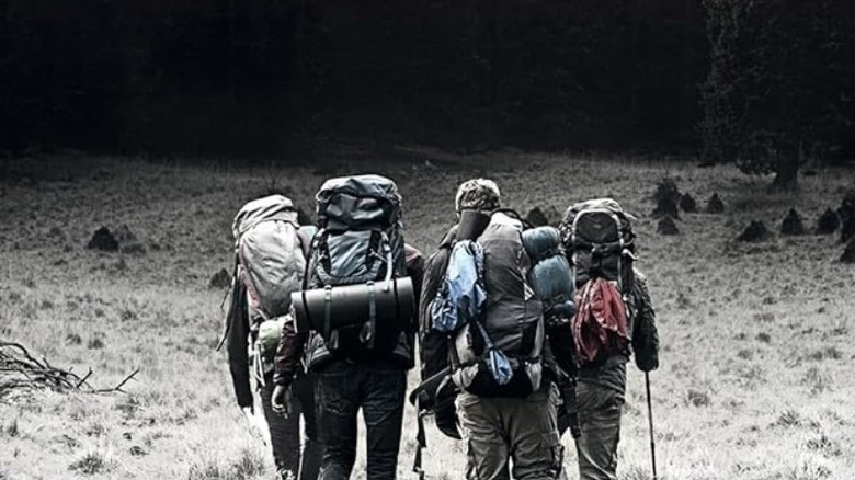 Friends walking in the wilderness on  the cover of Adam Nevill's The Ritual