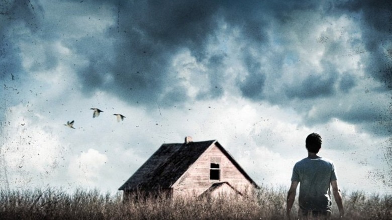 A man looking at a house in the distance on the cover for Dean Koontz's Odd Apocalypse